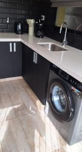 a kitchen with a washing machine and a sink at Hermosa Casa Con pileta y quincho in Villa Nueva +8 photos