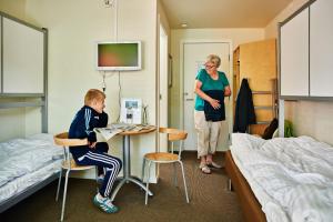 Ein kleiner Junge, der an einem Tisch in einem Krankenhauszimmer sitzt. in der Unterkunft Danhostel Aarhus in Arhus