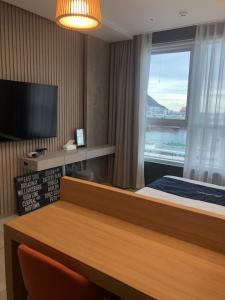a hotel room with a bed and a large window at Nampo The Bayment BLINGEASTERN in Busan