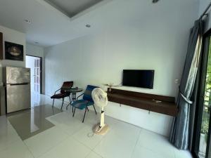 a living room with a flat screen tv on a wall at Nern Khao Guest House in Kamala Beach