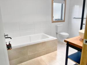 Un baño con bañera, inodoro y lavabo. en Alpine Edge Retreat- Gateway to Mount Buller, en Merrijig 7 fotos más