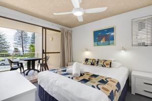 Un dormitorio con una cama y un balcón con una mesa. en Bellardoo12- Mooloolaba Beach, en Mooloolaba