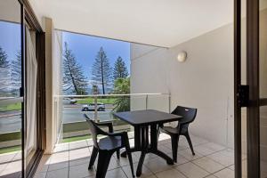 Un comedor con mesa y sillas y una gran ventana. en Bellardoo12- Mooloolaba Beach, en Mooloolaba