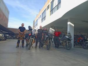 a group of men standing next to their motorcycles at Orquídea's Hotel in Piura