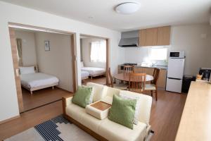 富良野TKD HOUSE FURANO的带白色沙发的客厅和厨房