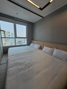 a large bed in a room with a large window at Nampo The Bayment BLINGEASTERN in Busan +63 photos