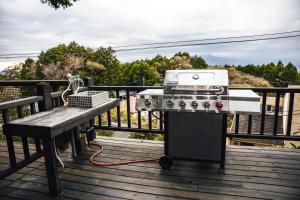 a grill on a deck next to a bench at 貸ログハウス奏 in Izunokuni