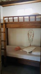 a bunk bed with two pillows and a chandelier at Pink Door Villa Gili Air, private pool & kitchen in Gili Air +8 photos