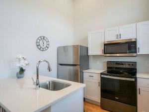 プロビデンスにあるJennifer's Historic Brick Riverfront Loft Apartmentのキッチン(シンク、ステンレス製の冷蔵庫付)