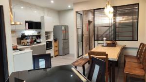 a kitchen and dining room with a table and chairs at Hermit Crab Guesthouse in Hengchun South Gate