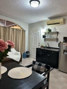 a kitchen and living room with a table and a refrigerator at Modern and Cozy Loft in La Ceiba