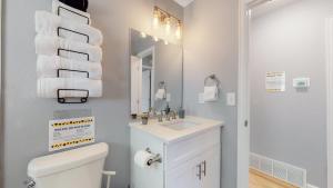 a bathroom with a toilet and a sink and a mirror at Updated Family Unit with Two King Beds in Denver