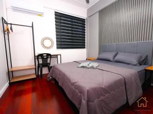 a bedroom with a bed and a table and a chair at Lyd's Home Urban Staycation in Sibu
