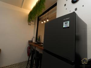 a black refrigerator in a room with a counter at Lyd's Home Urban Staycation in Sibu