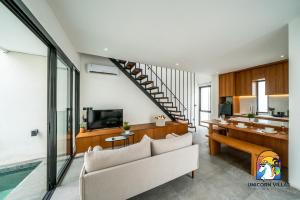 un salon avec un canapé et une télévision dans l'établissement Villa Akarui - by Unicorn Villas Bali, à Tumbak Bayuh