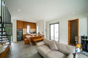 un salon avec un canapé et une cuisine dans l'établissement Villa Akarui - by Unicorn Villas Bali, à Tumbak Bayuh