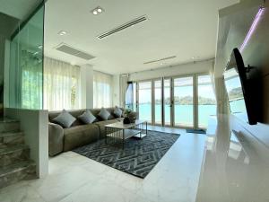 a living room with a couch and a table at Seaview Duplex Home - Panwa Beach - Baan Jayden in Phuket Town