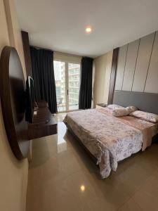 a bedroom with a bed and a flat screen tv at Apartment Nagoya Thamrin favehotel in Nagoya