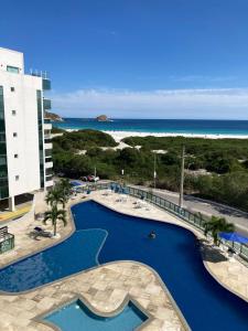 a view of a pool at a resort with the beach at Lindo Por Do Sol in Arraial do Cabo
