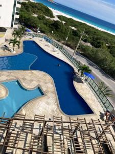 an aerial view of a swimming pool next to the beach at Lindo Por Do Sol in Arraial do Cabo