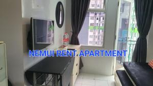 バンドンにあるJarrdin apartment Cihampelas 2BR pool view by Nemui Roomのリビングルーム(テレビ、窓付)