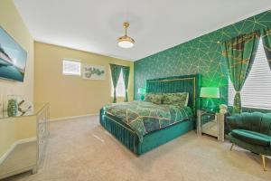 a green bedroom with a bed and a chair at The Bling Estate in Kissimmee