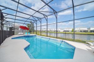 a large swimming pool with a large glass building at The Bling Estate in Kissimmee +20 photos