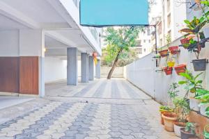 DāpuriSuper Collection O Baner formerly Seven Hills的一条空的街道,在建筑物的一侧有植物