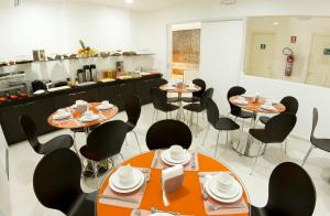 a room with tables and chairs and a kitchen at Pousada Eco Maceio in Maceió