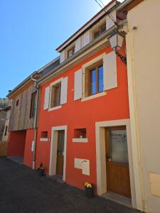 an orange building with doors and windows at Appartement proche Colmar in Soultzbach-les-Bains
