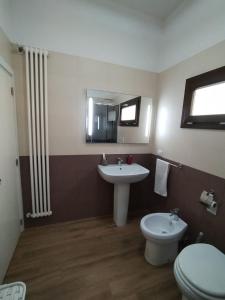 a bathroom with a sink and a toilet and a mirror at La Dolce Vita in Galatone