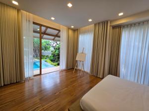 una camera con letto e vista sulla piscina di Baan Prod Pool Villa Chiang Mai a Chiang Mai Altre 52 foto