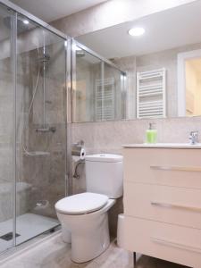 a bathroom with a toilet and a glass shower at Pension Mayte in Pamplona