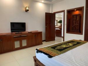 a bedroom with a bed and a flat screen tv at Hawaii Beach Bungalows in Sihanoukville