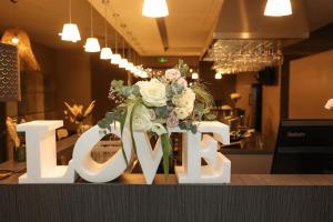 a sign that says love with a bouquet of flowers at Hôtel Château de Lacan in Brive-la-Gaillarde