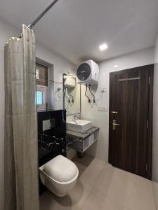 a bathroom with a toilet and a sink and a shower at Hotel Arohan Inn - Food & Stay in Jagatsukh