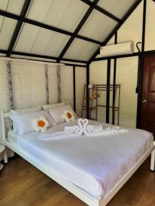 a white bed with flowers on it in a room at Lantamangrove in Ban Ru Yai