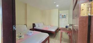 a hotel room with two beds and a mirror at OYO 1121 JUNLYN APARTELLE in Panglao Island +18 photos