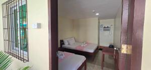 a small room with two beds and a mirror at OYO 1121 JUNLYN APARTELLE in Panglao Island