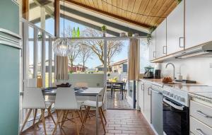 una cucina con mobili bianchi, tavolo e sedie di Holiday Home Aabenraa With Fireplace 11 a Aabenraa