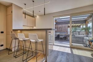eine Küche mit einer Bar mit Hockern und einem Esszimmer in der Unterkunft City CENTRAL Apartment - Attico Porto Brenzone -lakefront rooftop terrace in Brenzone sul Garda