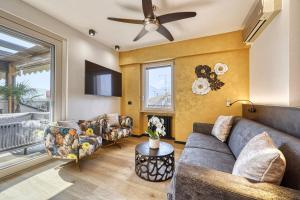 ein Wohnzimmer mit Sofa und Fernseher in der Unterkunft City CENTRAL Apartment - Attico Porto Brenzone -lakefront rooftop terrace in Brenzone sul Garda