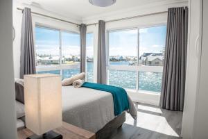 a bedroom with a bed with a view of the water at 33 Kingston Place, Marina Martinique in Jeffreys Bay