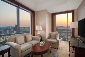 a living room with a couch and chairs and a television at Shangri-La Suzhou in Suzhou +33 photos