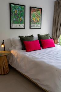 Una cama blanca con dos almohadas rojas. en Seabreeze Mont Choisy Apartment, en Trou aux Biches 23 fotos más