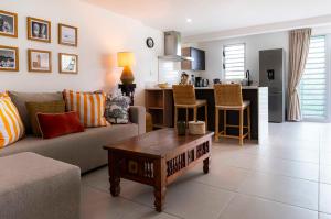 una sala de estar con un sofá y una mesa en Seabreeze Mont Choisy Apartment, en Trou aux Biches