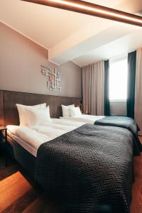 a hotel room with two beds and a window at Clarion Hotel Mestari in Helsinki