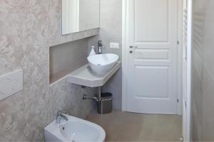 a white bathroom with a sink and a toilet at Villa Pescoluse with Pool and Sea View - Happy Rentals in Salve