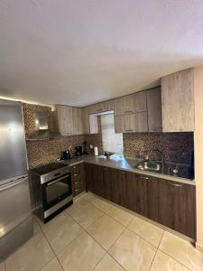 a kitchen with wooden cabinets and stainless steel appliances at Villa Makri in Makri