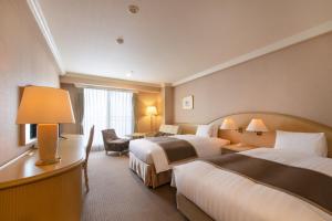 a hotel room with two beds and a desk at Rusutsu Resort Hotel & Convention in Rusutsu